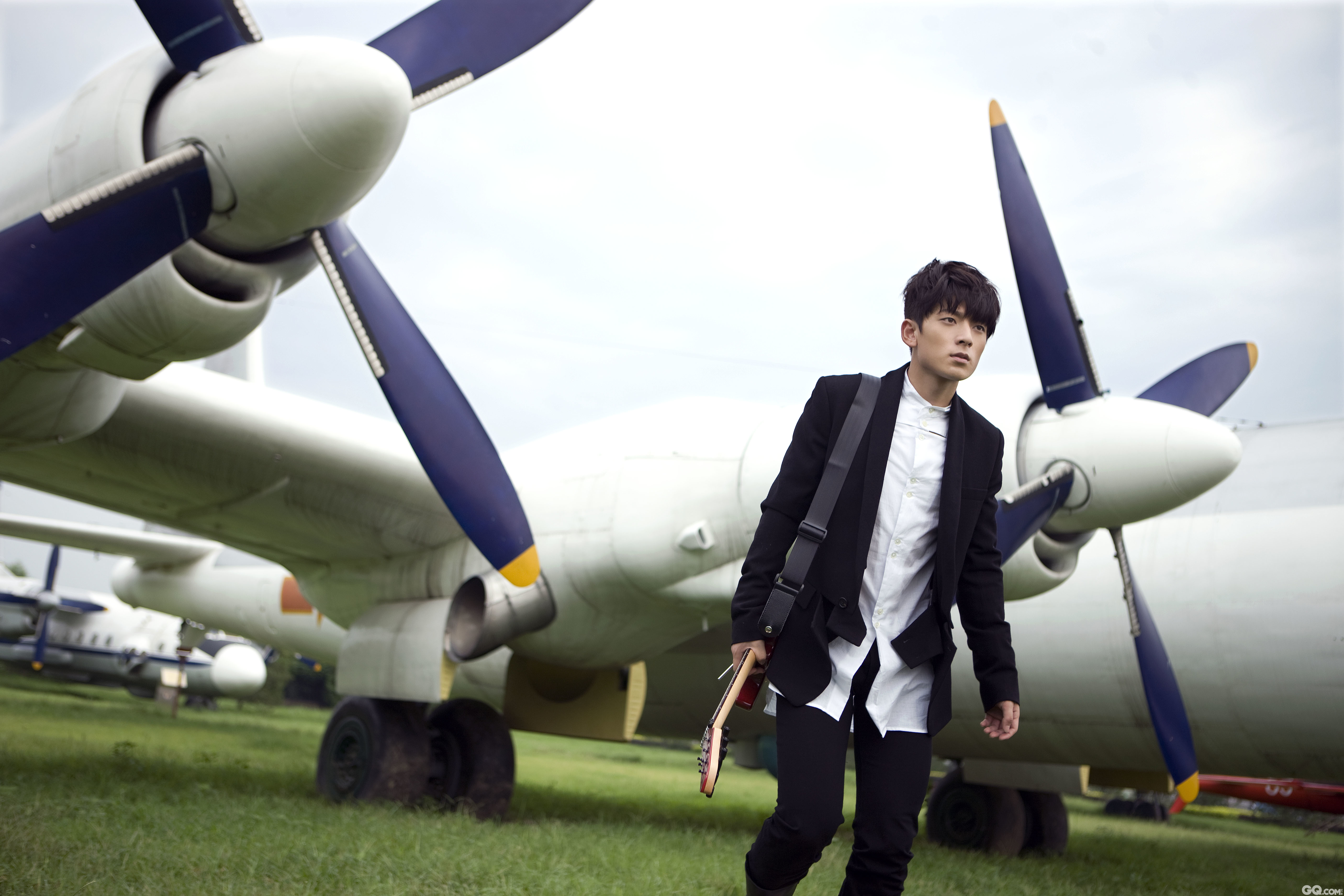 2011年，陈翔拍摄写真。他身着黑外套白衬衣，简约装扮而又帅气逼人，行走在机翼间。
