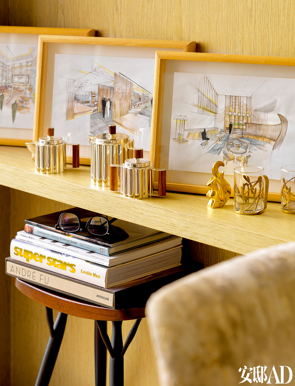  André 喜欢木头与皮的质感，其间搭配一些黄铜的光泽 ，低调之中又不失奢华 。客厅架子上的Alessi茶具和他 为新加坡浮尔顿酒店和香港滩万餐 厅项目竞标手绘的草图。
