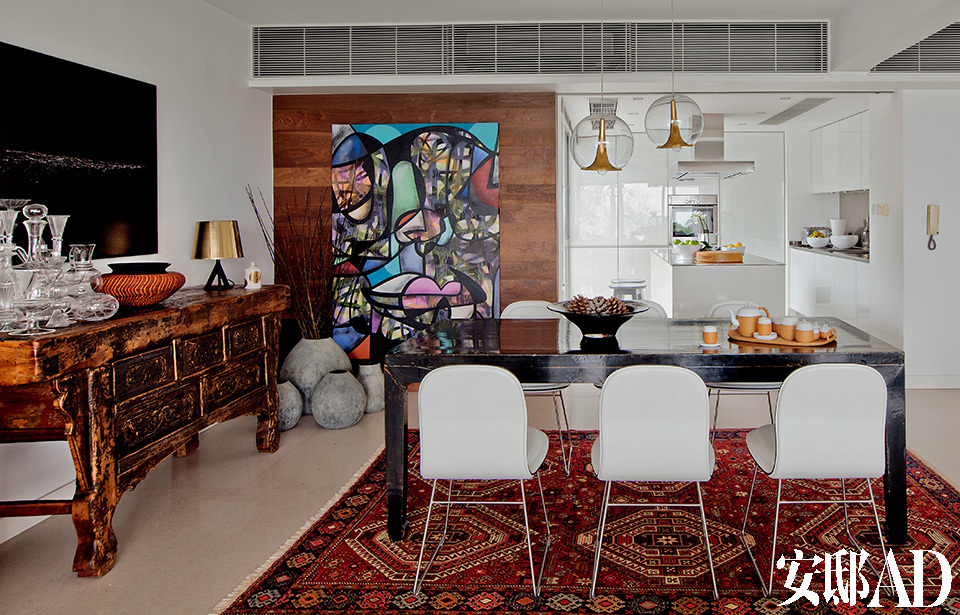 一张色彩绚丽的涂鸦画作，加上一张来自伊斯坦布尔大集市 的土耳其地毯，在家里浅色的背景中显得颇有生气。餐厅采用了法国石灰石和胡桃木的基础元素，以求尽量将空间和采光最大化。左侧黑色的印刷照片是Dries van Noten赠送给Andrew Keith
的礼物，来自Cappellini的6把白色皮革Hi Pad餐椅由Jasper Morrison设计，围绕着一张明代古董餐桌，餐桌上方的吊灯来自Bosa Lighting Lights，桌子上的竹编茶具来自“上下”。