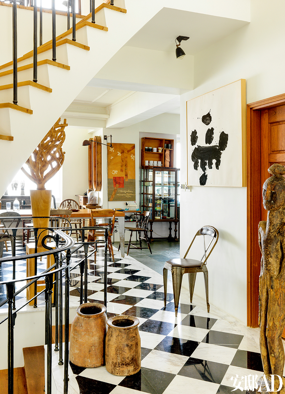 开放式餐厅、厨房直接与门廊相连，光线明媚、空间流畅，是柯爸在这个家中待得最多的地方。从门廊看向餐厅，中景处的木质艺术品是范姜明道创作的。