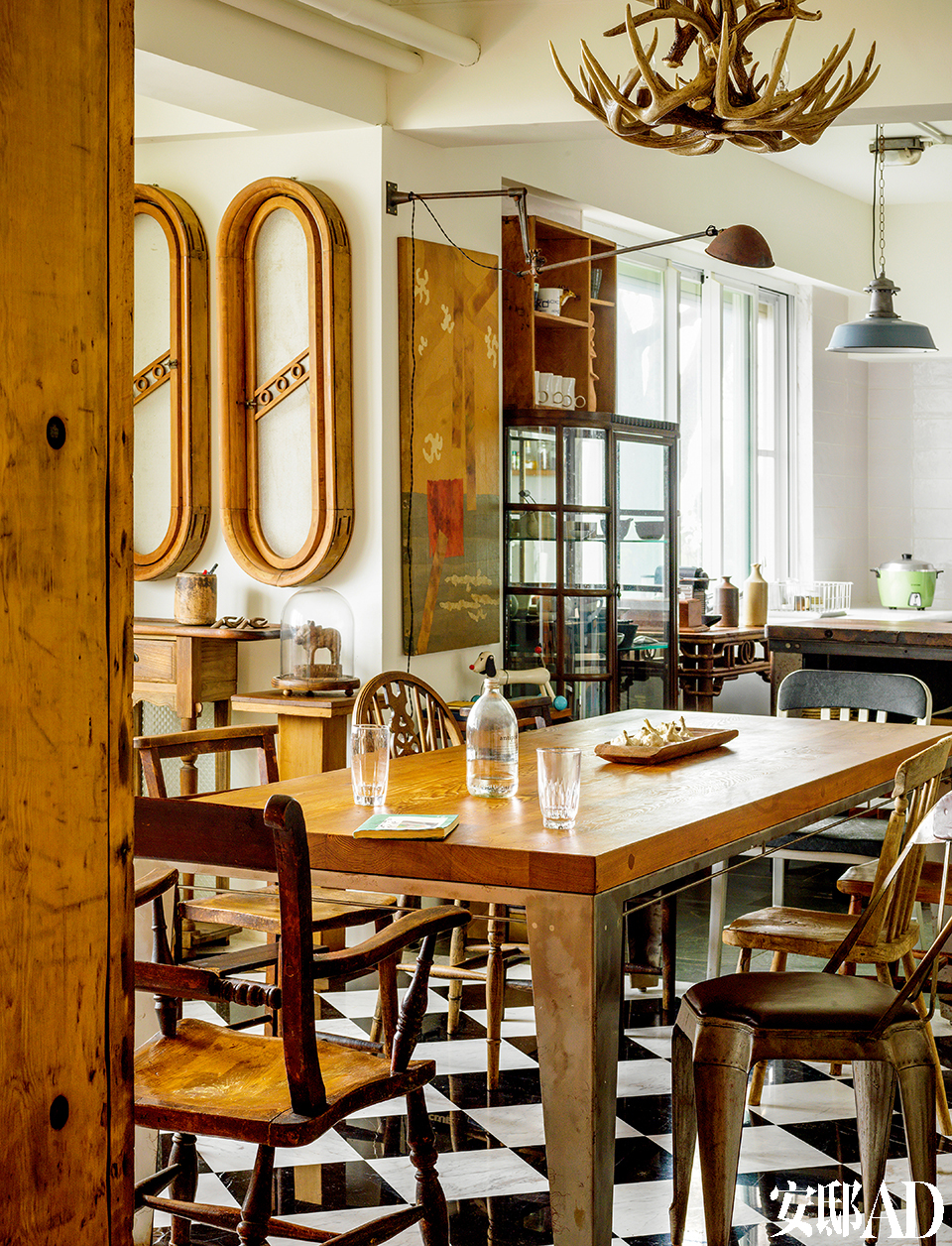 餐厅与厨房开放相连，光线十分
明媚。台湾老桧木餐桌周围摆放着各不相同的几把古董椅，它们都是柯爸的心头好。