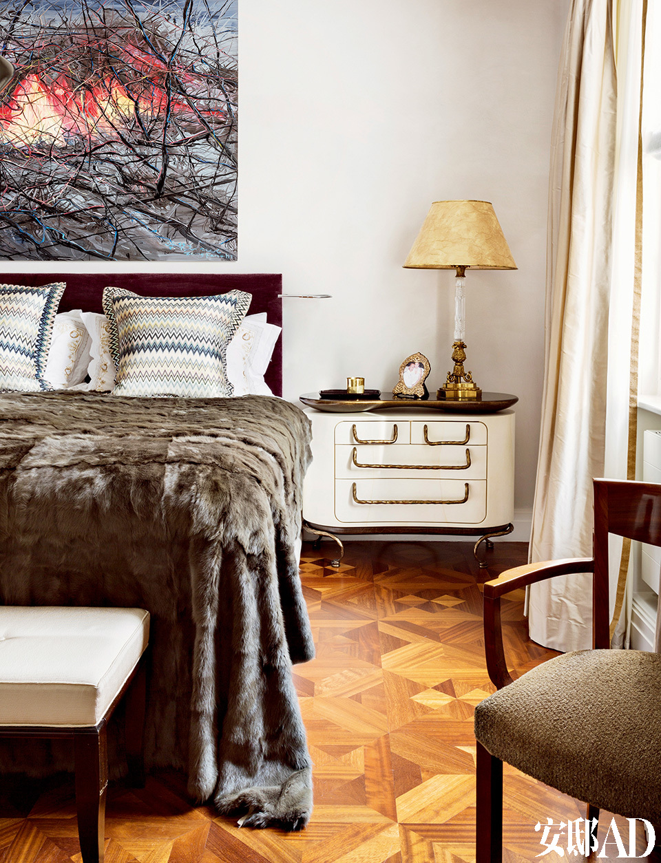 在主卧室里，床头柜是Mattia Bonetti受David Gill画廊委托做的设计，修剪整齐的水貂毛床罩磅礴地一直垂落到床脚，床头上挂着的是曾梵志的作品。