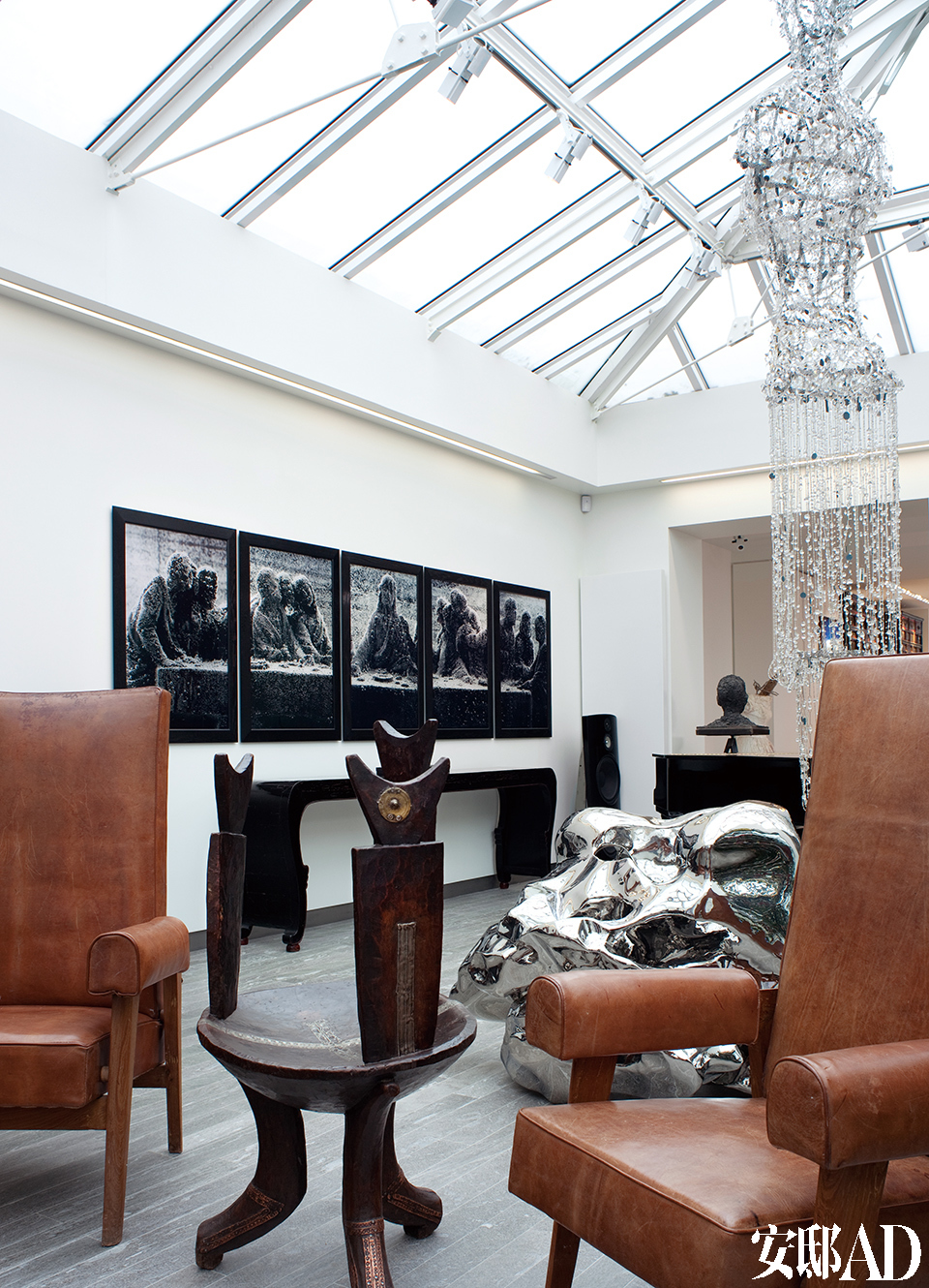 主人对中国艺术家的关注与喜爱一目了然，张洹、展望、张晓刚的作品与众多世界级大师的作品共处一室，毫不突兀。 画廊细节。Chandigarh Judge系列皮木制扶手椅来自Pierre Jeanneret；中间的非洲椅子源自埃塞俄比亚，制成于20世纪20年代； 靠左边的墙面上，挂着Andres Serrano的系列画作：《Immersions，Black Support I to IV》。