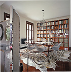多塊斑馬皮地毯令餐廳眼前一亮，帶金屬網椅背的餐椅，與餐廳及客廳之間的金屬屏風極為呼應。分隔餐廳與客廳之間的屏風，金屬框架內搭配了一種灰色金屬細網，為線條明晰的室內風格添加一縷朦朧。Maxalto品牌的餐桌搭配了來自B&B Italia的Iuta金屬扶手椅，正上方懸掛著由Gino Sarfatti設計的Flos吊燈。