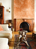 即使是大艺术家曾经最重要的作品之一，在家里也能与残缺的石像、筋骨尽显的树根茶几和谐相处。西式沙发的舒适，搭配树根茶几的筋骨，在这个空间内显得气质独特。更妙的是颜色的选择，窗帘和壁炉都用了浅橙色，优雅中又透着新鲜。