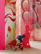 “我把生活当作一场不可思议的冒险，每天都有新刺激，这太美妙了。”背景中入口处的墙绘由巴黎街头艺术家Rude（3HC）创作，彩色机械狗来自Prada。
