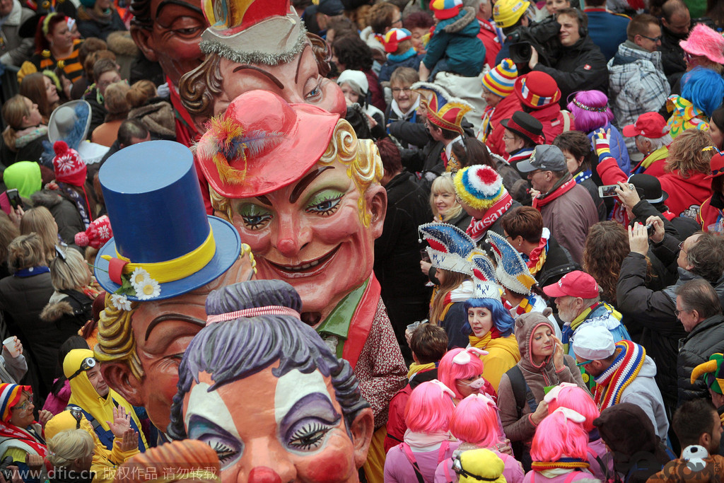 当地时间2014年11月11日，在德国杜塞尔多夫，狂欢者身着五彩斑斓的服饰，浓妆艳抹，将自己装扮成小丑庆祝狂欢节。