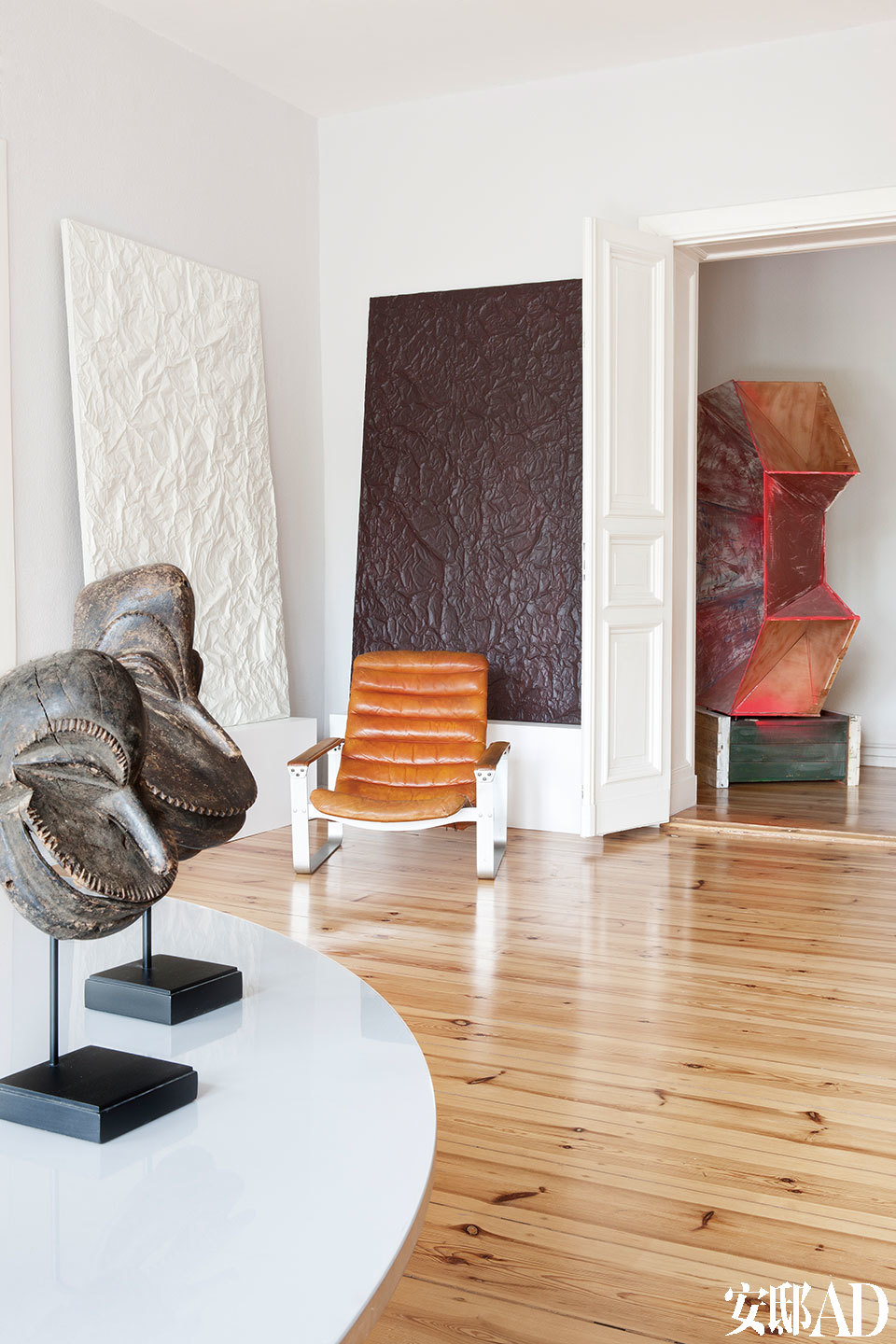 “ 在我的家里，每个房间都是一个简单的白色立方体， 它们相连在一起，就仿佛一座特别的个人收藏馆。”靠墙的一黑一白两幅画作名为《And，Une》，出自Guillaume Leblon之手，一旁的金属架皮革扶手椅由Ilmari Lappalainen设计，近处的桌面上摆设着几只非洲部落风的头像雕塑，来自瑞士年轻艺术家Flurin Bisig。