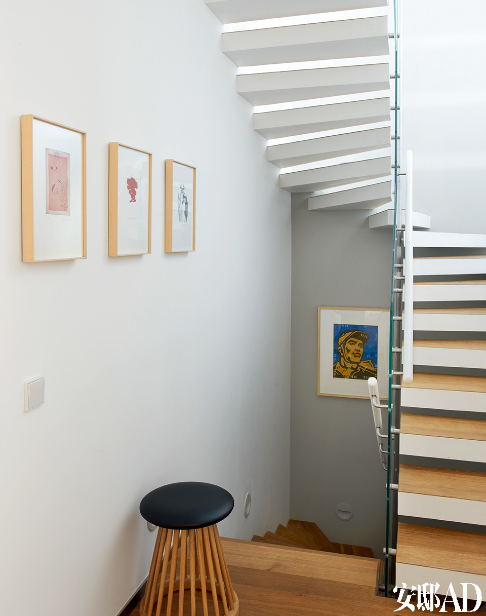 楼梯间，近处墙面上的三幅小画来自德国艺术家伊门多夫，楼梯下挂着一幅艺术家王广义的作品。