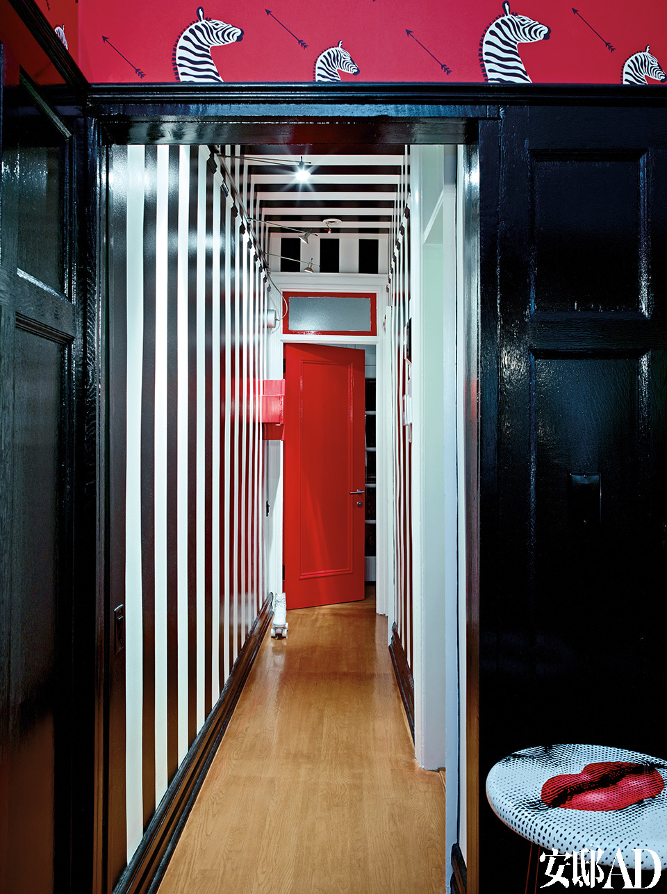 门厅中黑白条纹的特制墙面装饰受到了20世纪60年代童年回忆的影响（太空时代，Verner Panton和Pierre Cardin）。黑白条纹墙纸让原本狭窄的走廊呈现出视觉扩张的效果，白色部分是亚光，黑色部分特意选择高光，灯光下显示得更精致。