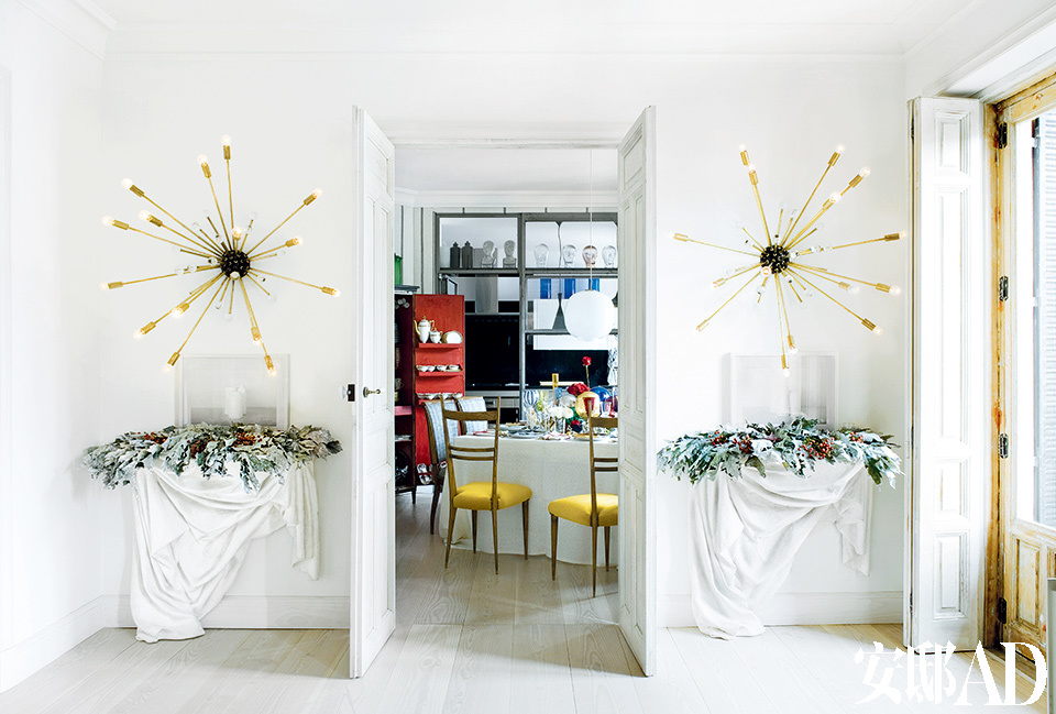 檞寄生和圣诞树平放在一对在Alejandro Fauquié购买的Frédéric Méchiche石膏靠墙小桌上。小桌的上面还各摆放着一幅在Inés Barrenechea购买的Maite Labiaga的摄影作品。壁灯为Jon Urgoiti，往里是餐厅和厨房。