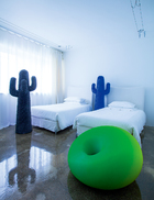 卧室里的绿色椅子来自Detecma，是Tullio Regge在1967年设计的。两个蓝色“仙人掌”衣架，分别是Drocco/Mello在2010年和2015年设计的。