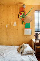 在孩子们的卧室里，墙上挂着故事插图和手册。白色壁灯是IKEA PS 2012，学校的老椅子被搬了回来，书桌上还摆着Richard Woods设计的Tree Trunk Base的原型。